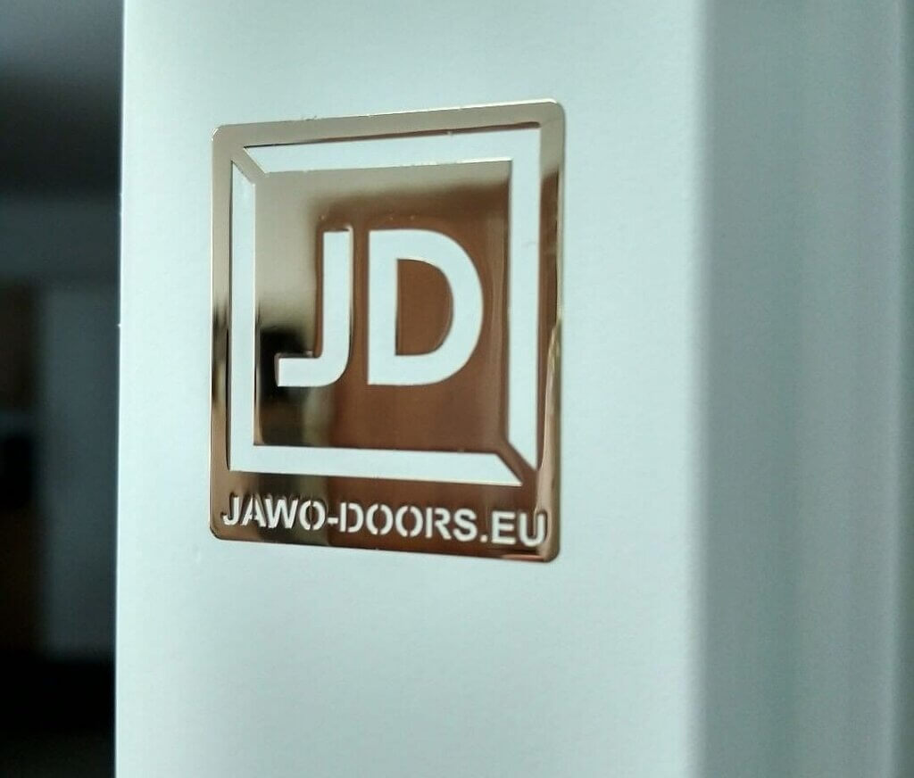 chromowany prostokątny emblemat z logo firmy Jawo