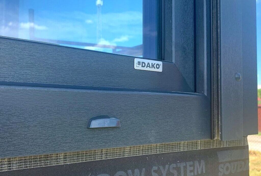 Srebrny emblemat logo Dako na oknach
