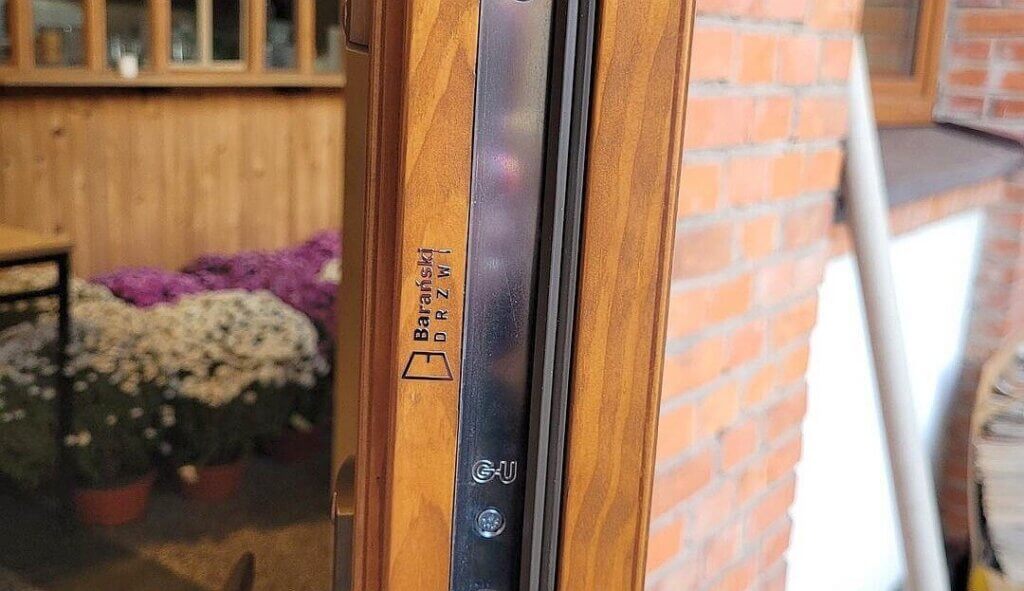 chromowane logo baranski drzwi na drewnianym profilu