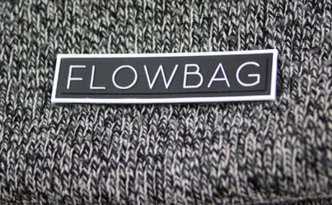 Czarno-biała prostokątna naszywka z logo firmy Flowbag