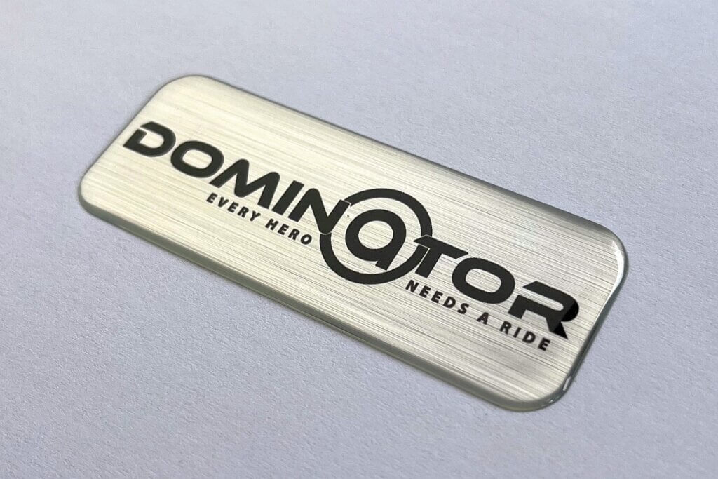 naklejka wypukła srebrna szczotka logo dominator