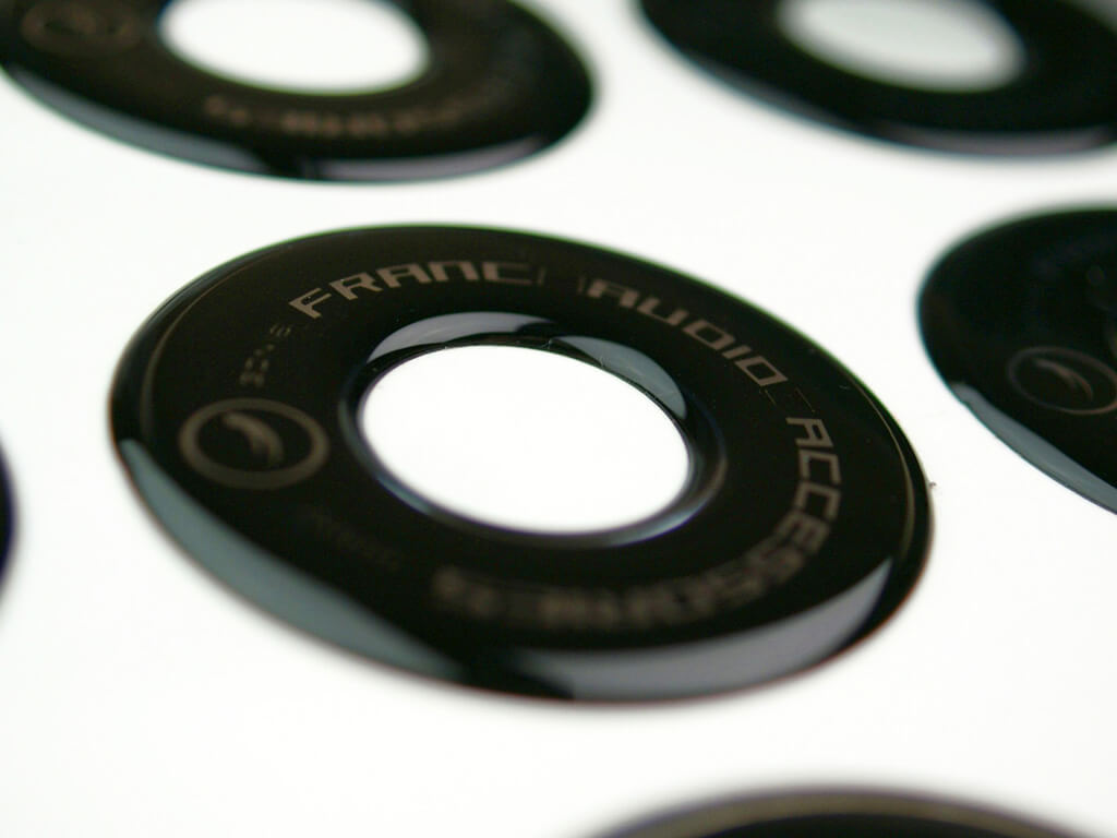 Czarna naklejka wypukłe okragła z wcięciem z logo firmy Franc Audio Accessories